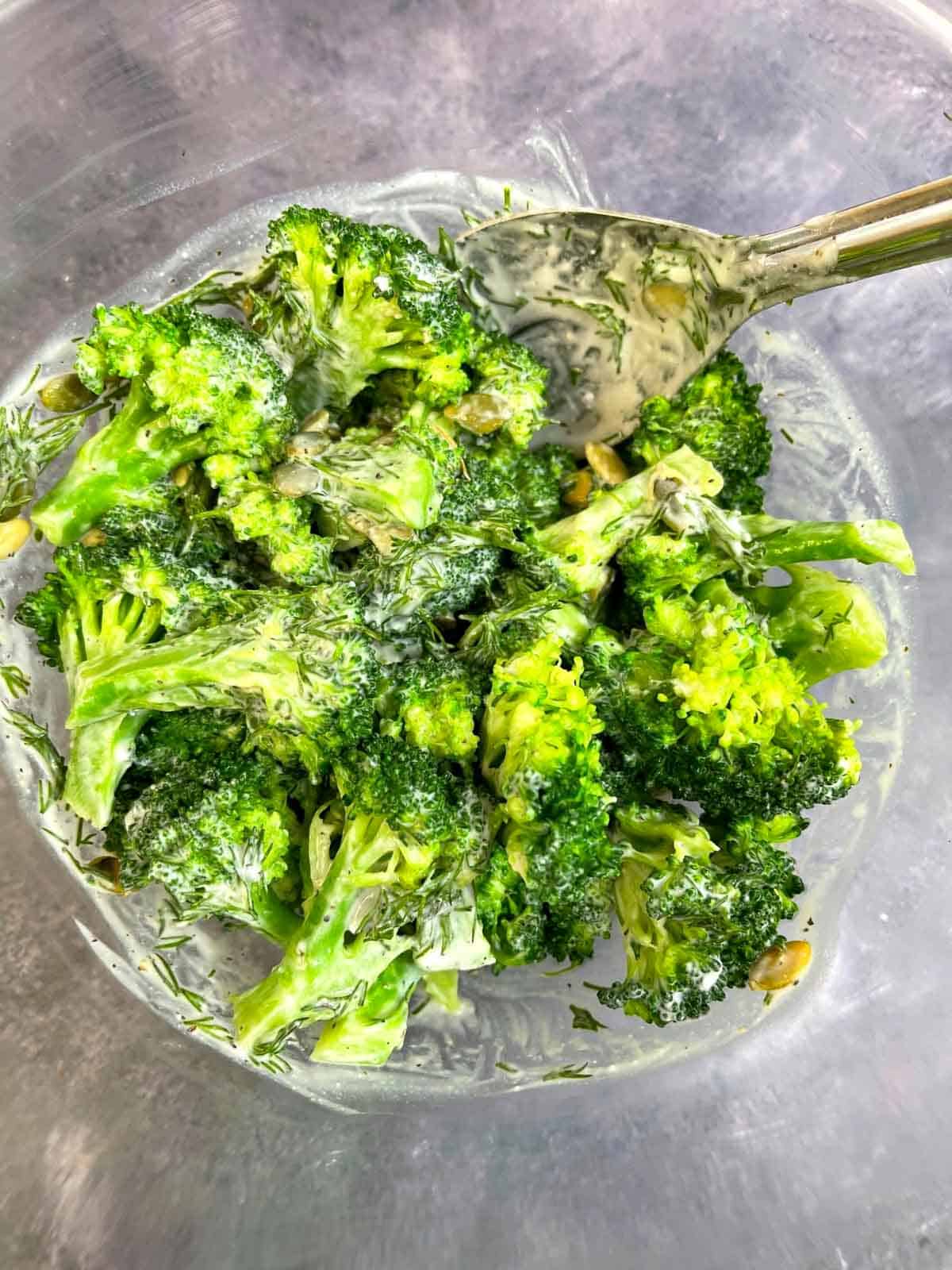 creamy broccoli salad in a bowl with a spoon