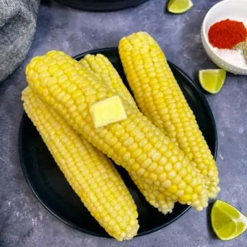 corn on the cob served on a plate with butter on the top