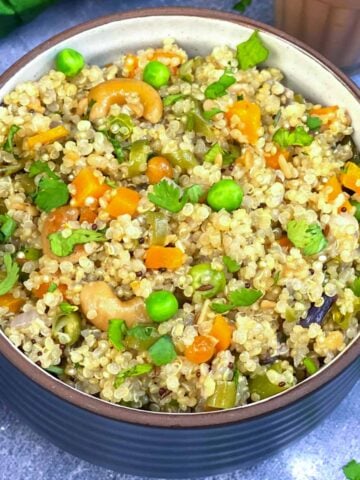 quinoa upma served in a bowl with masala chai on the side