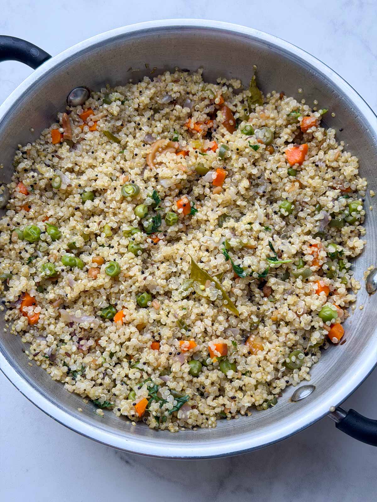 Vegetable quinoa upma in a steel kadai
