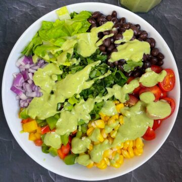 southwestern salad topped with avocado sauce in a bowl