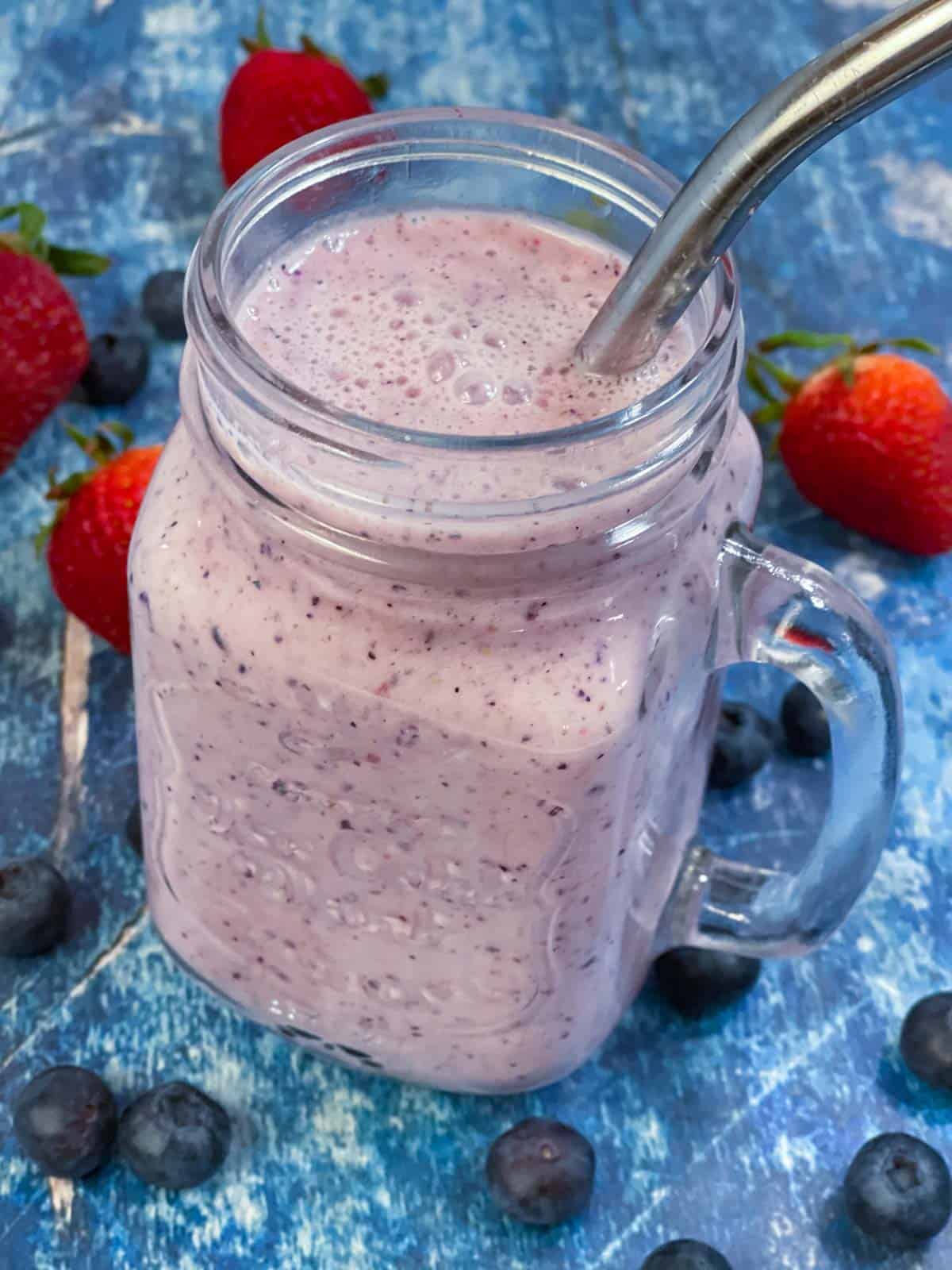 Strawberry Blueberry Smoothie served in a glass jar with strawberries and blueberries on the side