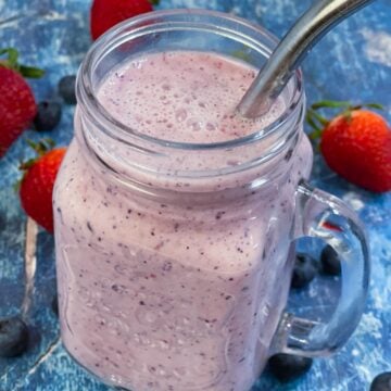 Strawberry Blueberry Smoothie served in a glass jar with strawberries and blueberries on the side