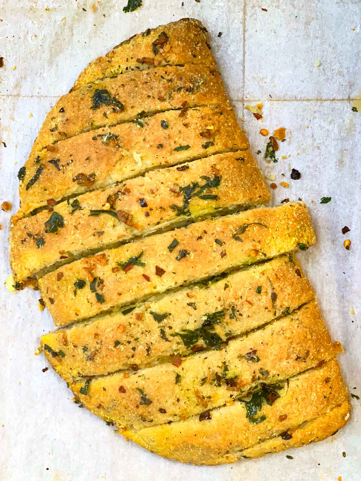 dominos style stuffed garlic bread served on a plate garnished with italian seasoning