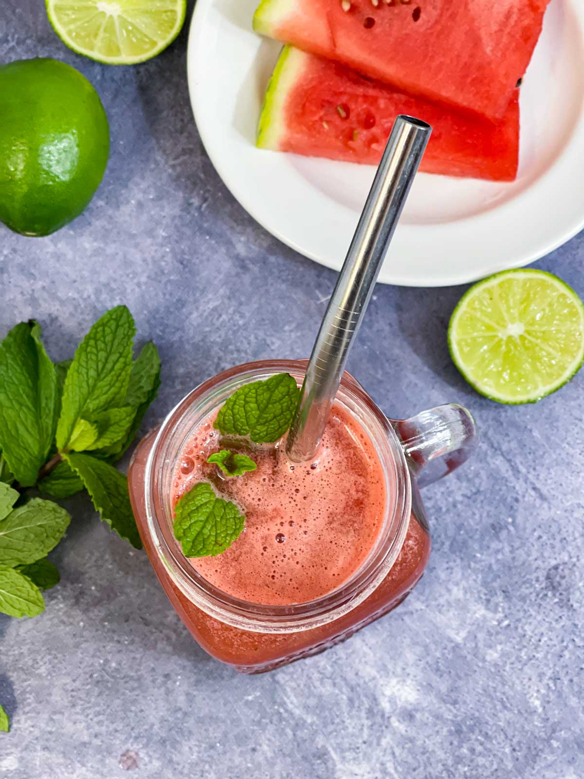 watermelon juice in a mason jar with watermelon slices, mint and lime on the side