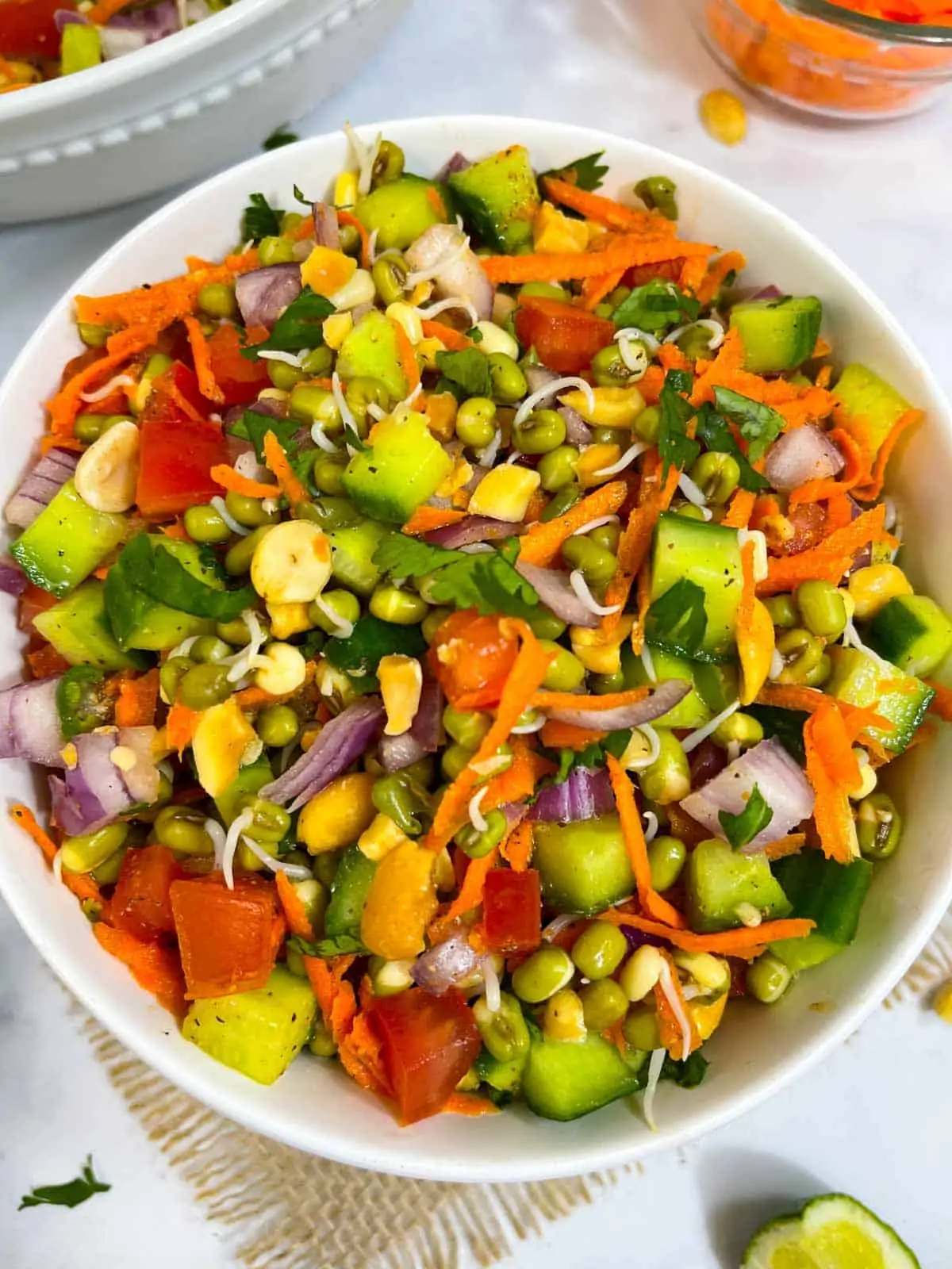 sprouted moong (mung) salad recipe served in a bowl with lemon wedge on the side