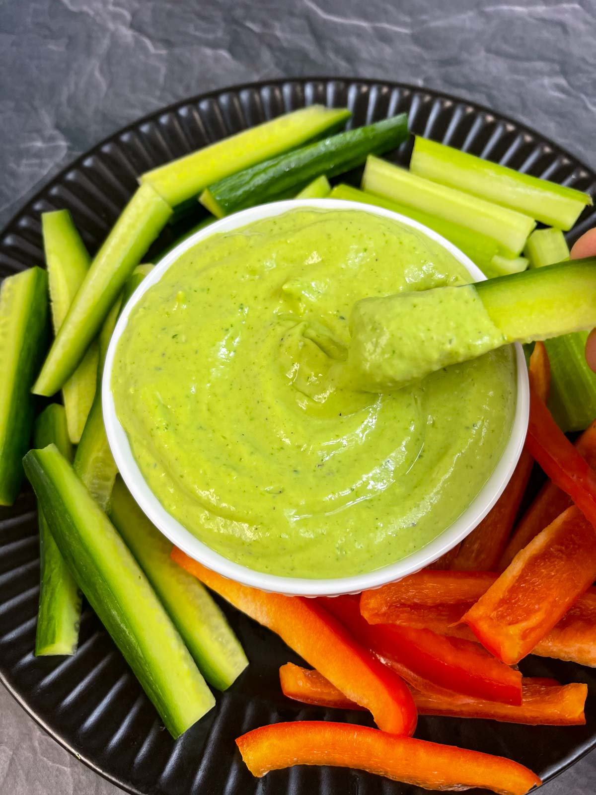 Creamy Avocado Cilantro Dip served in a bowl with vegetable sticks on the side