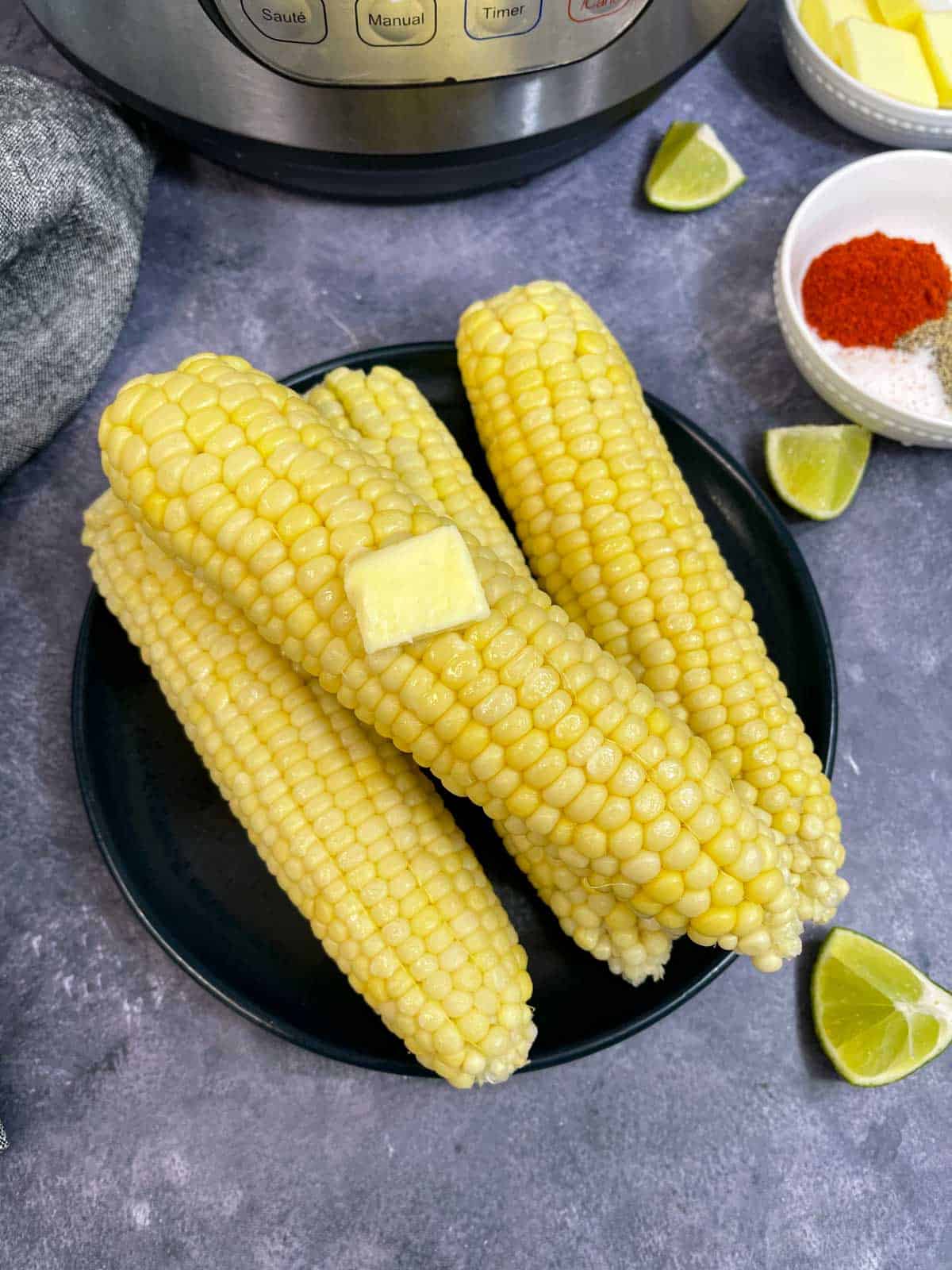 instant pot corn on the cob served on a plate with some butter on the top 