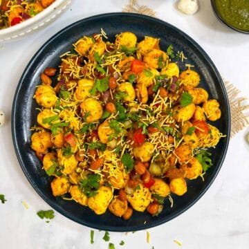 makhana bhel served in a plate garnished with sev and coriander