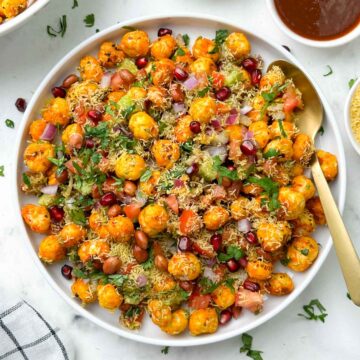 phool makhana bhel/ makhana chaat served in a plate garnished with sev and pomegranate with chutneys on the side