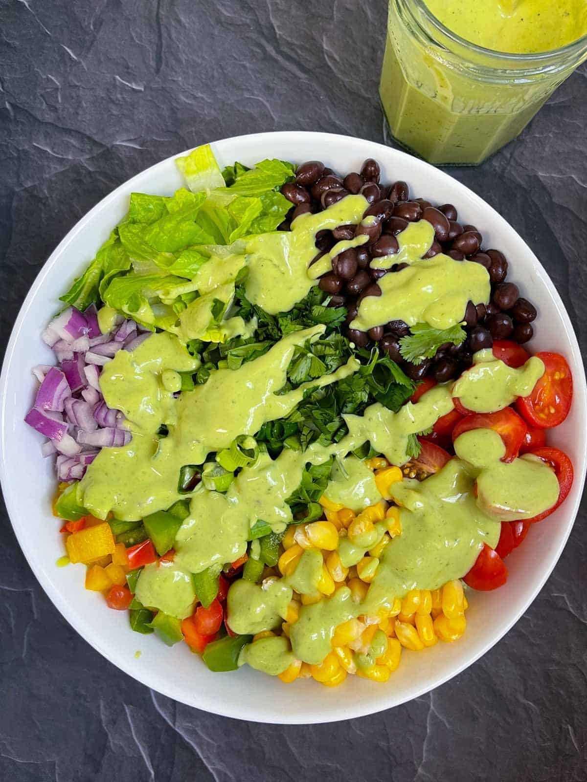 southwestern salad in a bowl topped with avocado lime dressing