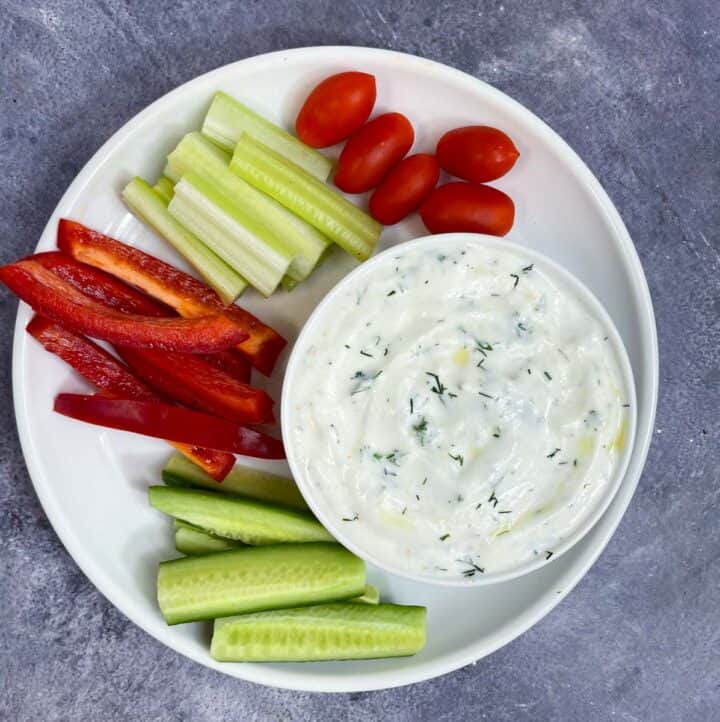 yogurt dill dip served in a bowl with side of veggies