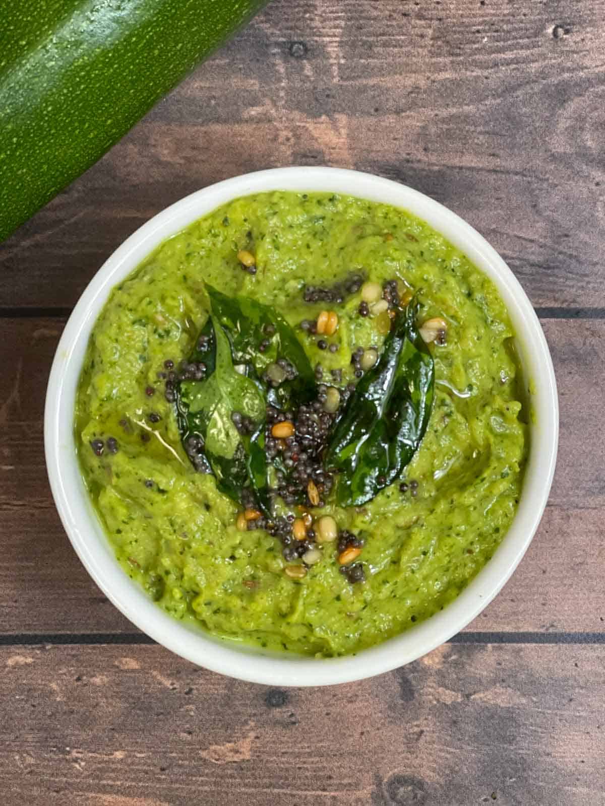 zucchini chutney served in a bowl with tempering on the top