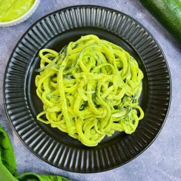 zucchini pasta with avocado sauce served on a plate