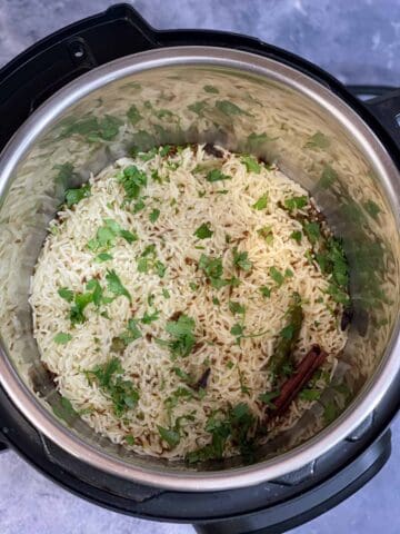 perfectly cooked jeera rice recipe in an instant pot pressure cooker garnished with cilantro