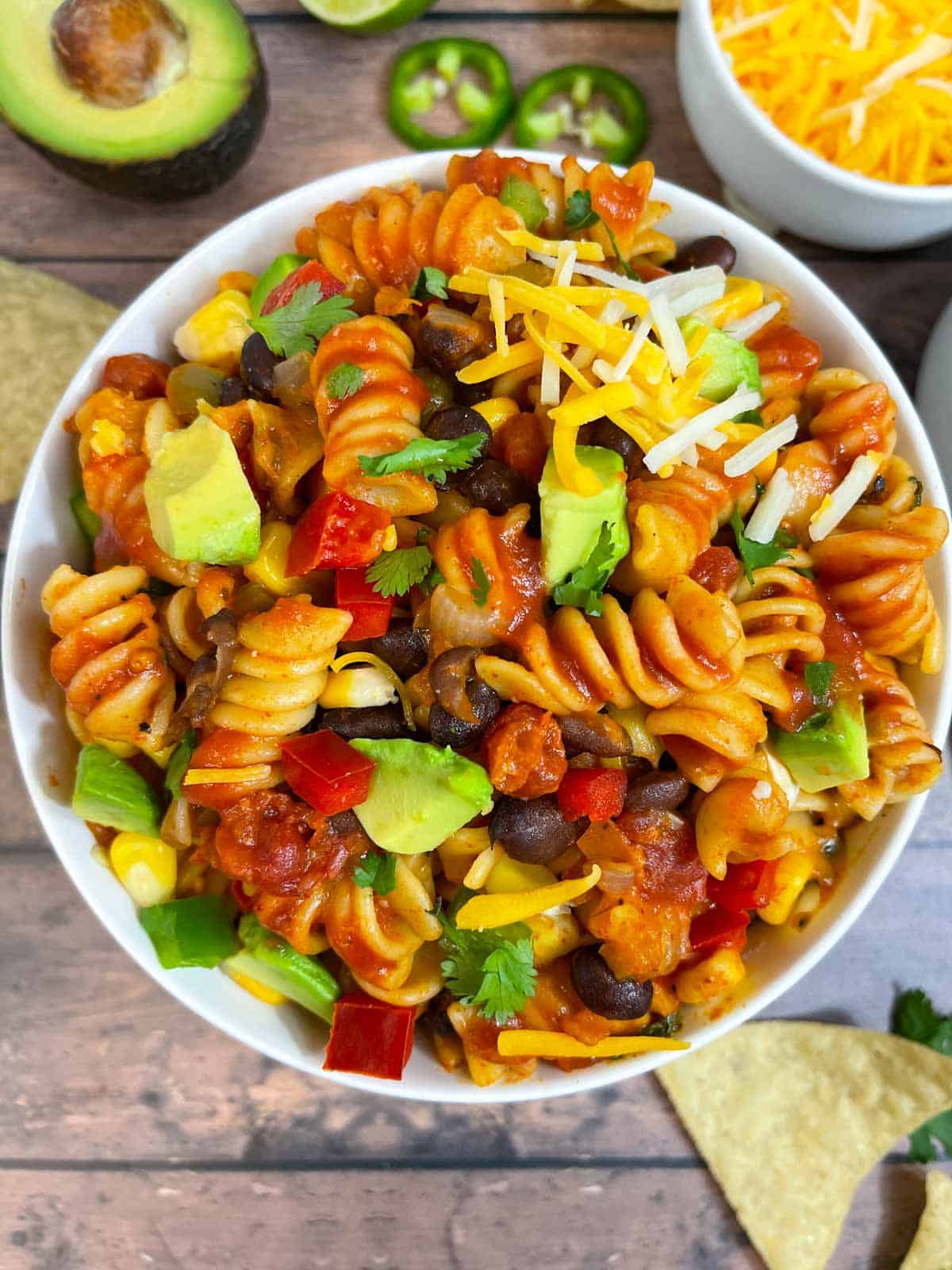 instant pot taco pasta dish served on a bowl garnished with cheese, avocado and cilantro