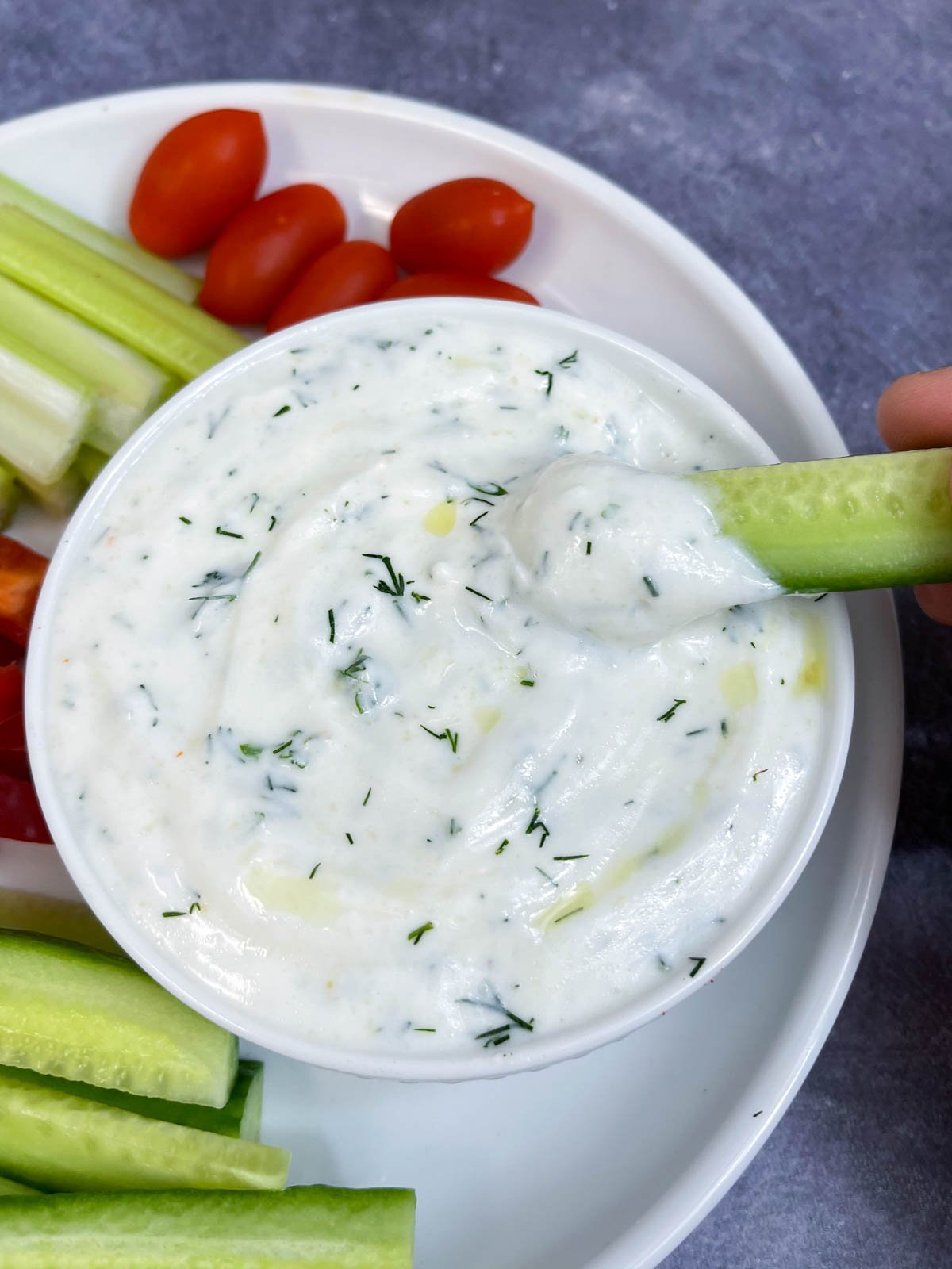 cucumber slice dipped in a yogurt dipping sauce 