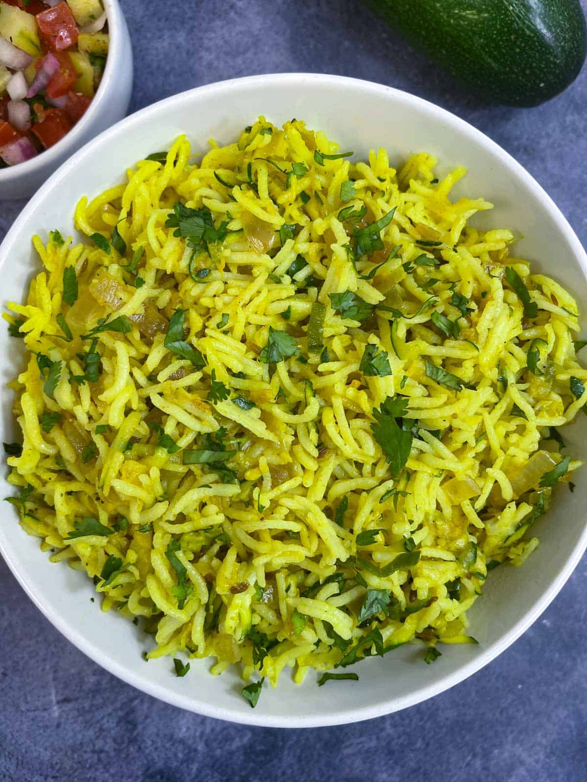 zucchini rice pilaf served in a bowl garnished with coriander leaves