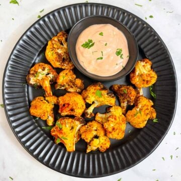 air fried cauliflower in a plate with sauce on the side