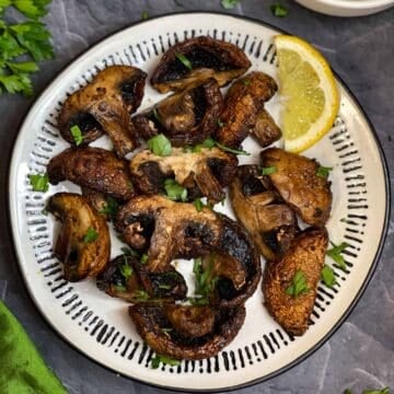 air fried mushrooms on the plate with a lemon wedge