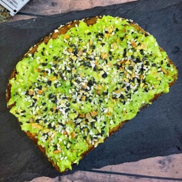 avocado toast with everything bagel seasoning placed on a black slate