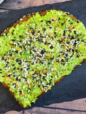 avocado toast with everything bagel seasoning placed on a black slate