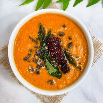 chana dal chutney served in a bowl with tempering on the top