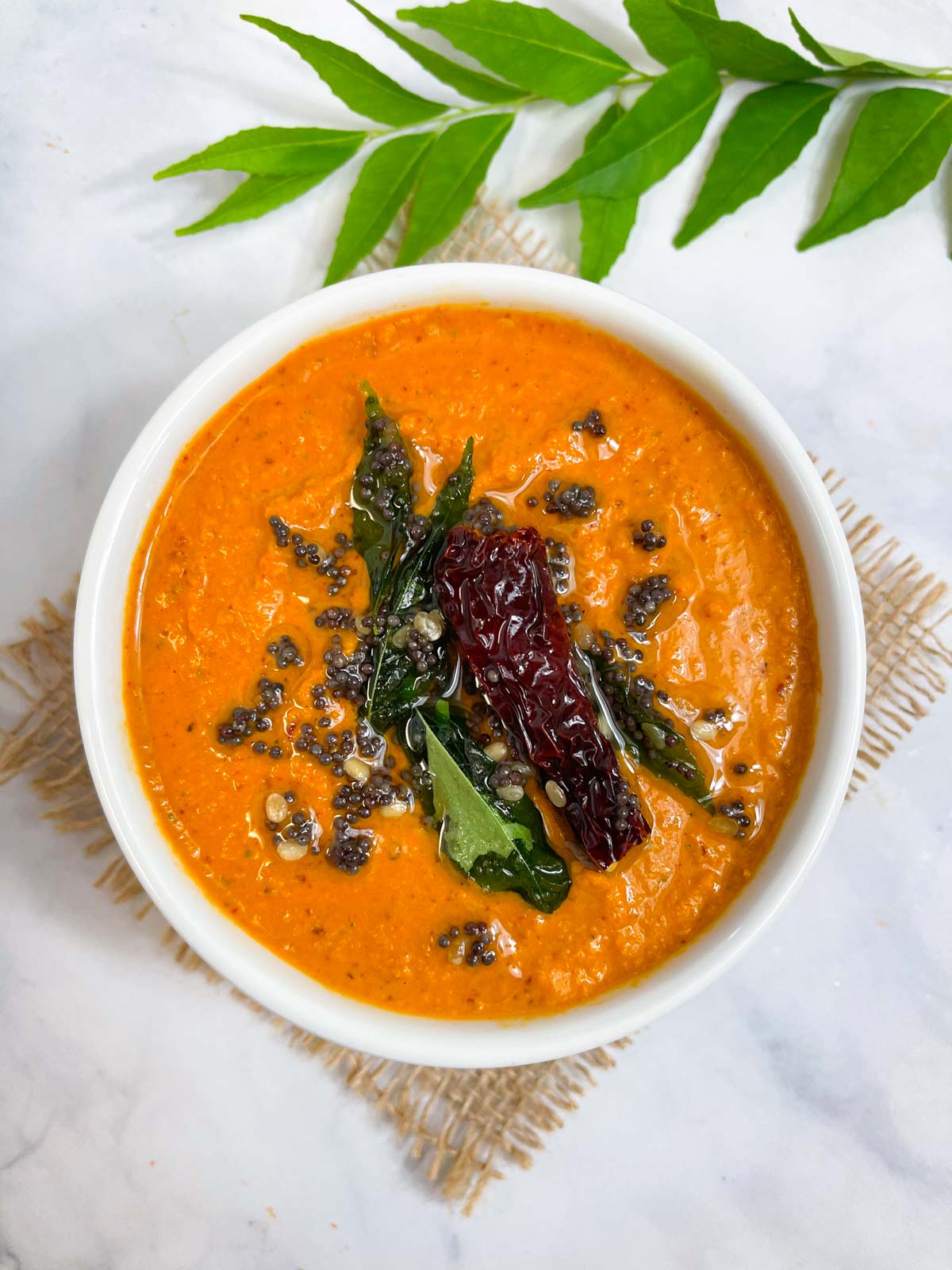 chana dal chutney served in a bowl with tempering on the top