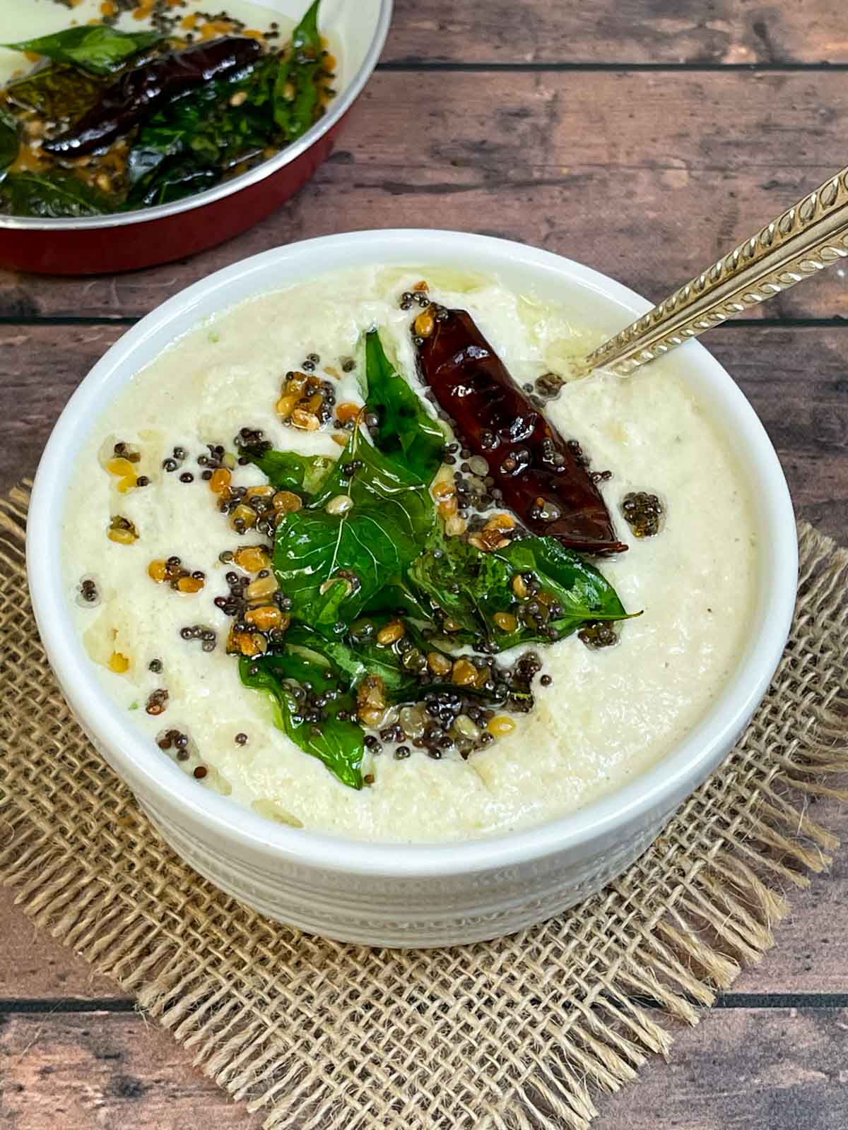 coconut chutney served in a bowl with tempering on the top