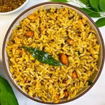 curry leaves (Karibevu Chitranna) rice served on a plate with podi and curry leaves in the side