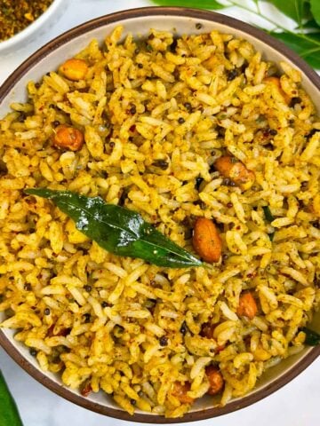 curry leaves (Karibevu Chitranna) rice served on a plate with podi and curry leaves in the side