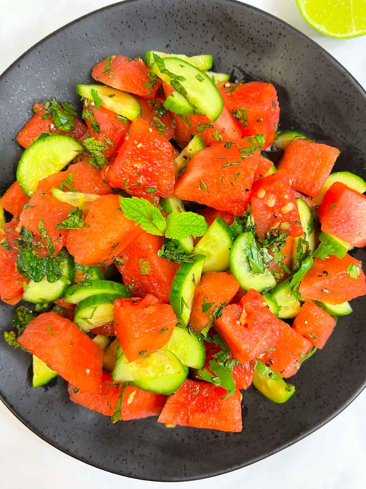 watermelon salad served on plate garnished with fresh mint