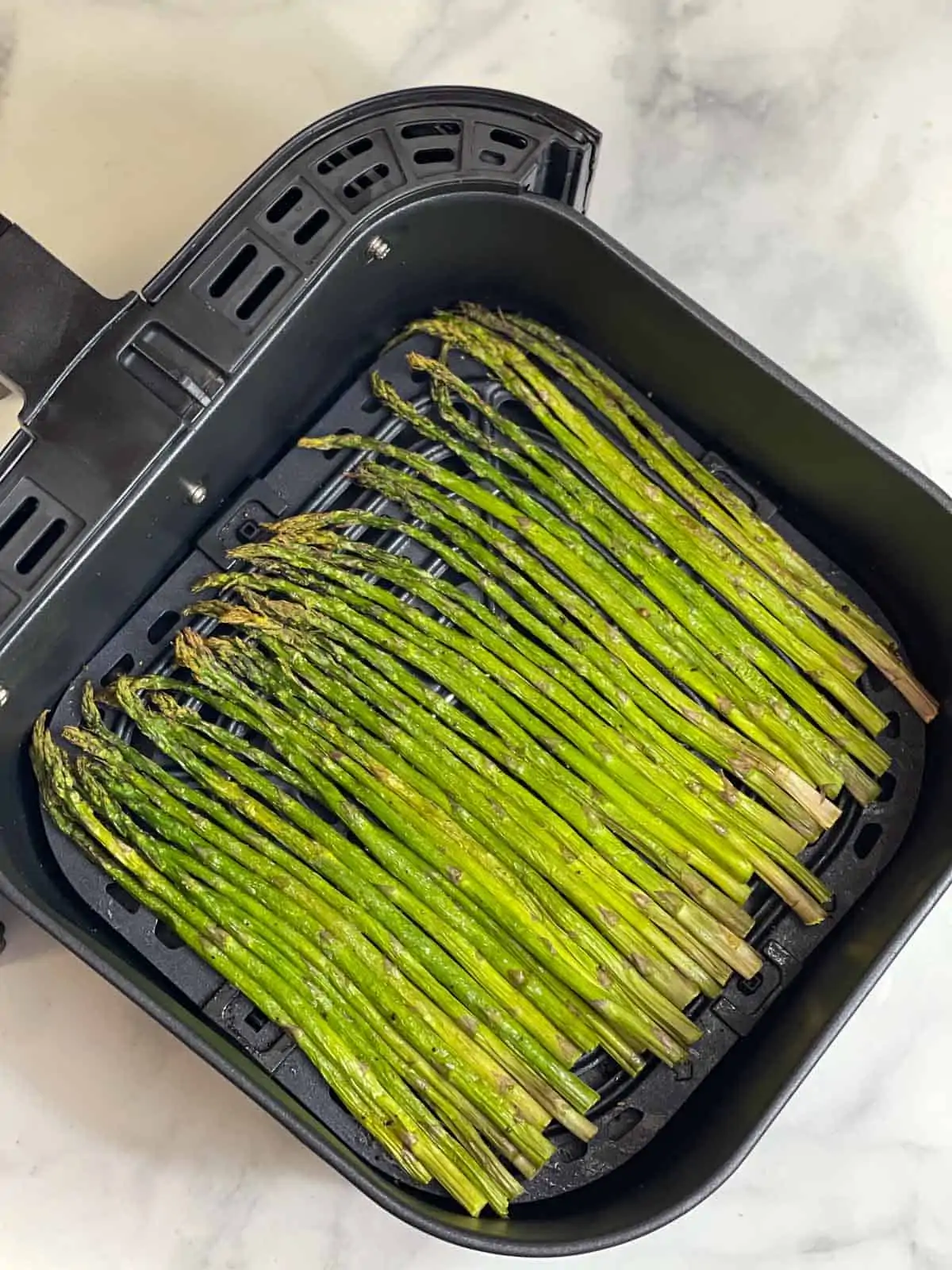 air fried asparagus in an air fryer basket