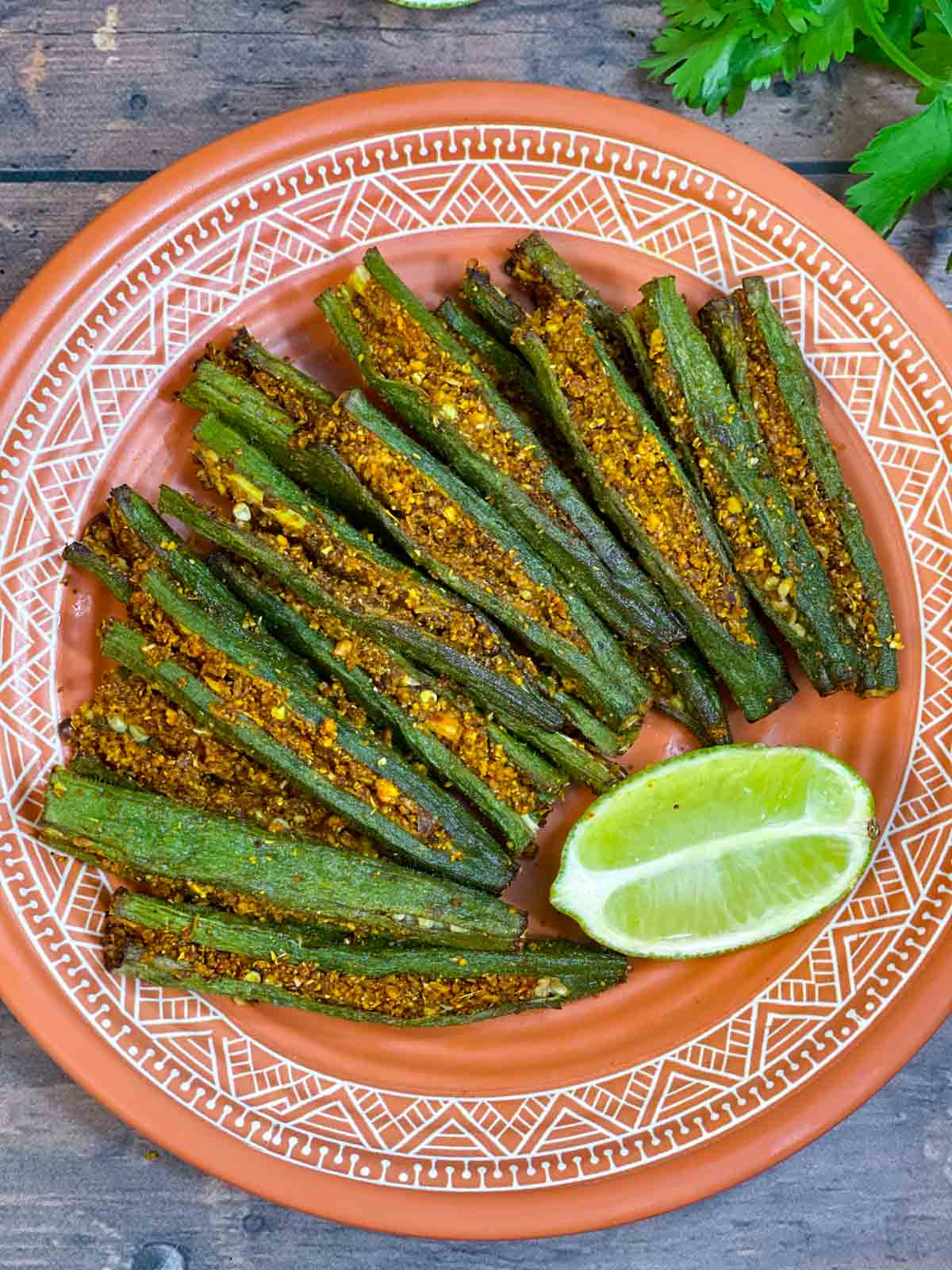 air fryer bharwa bhindi served on a plate with a lime wedge