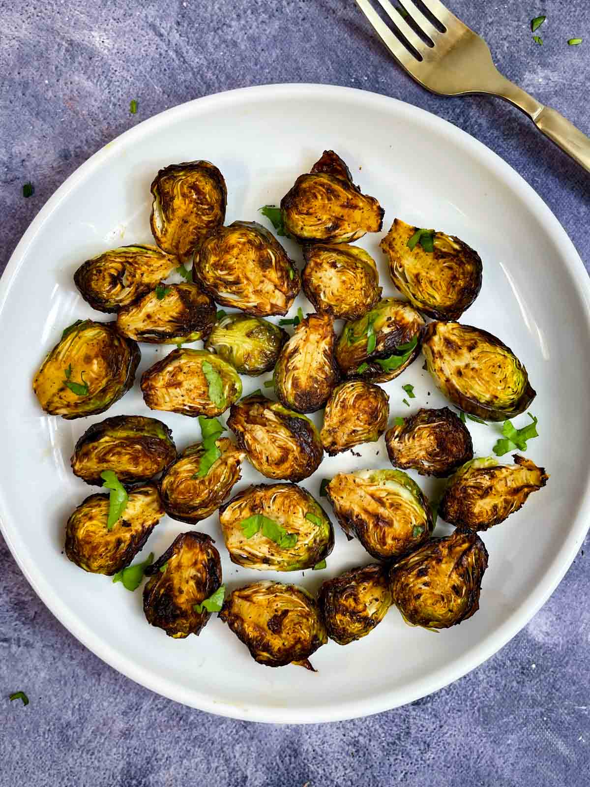 air fryer brussels sprouts served on a plate garnished with cilantro
