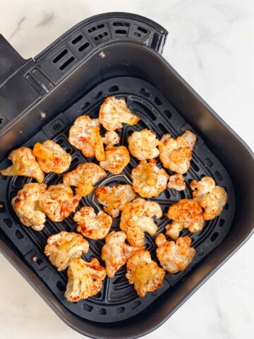 step to spread the seasoned cauliflower in the air fryer basket