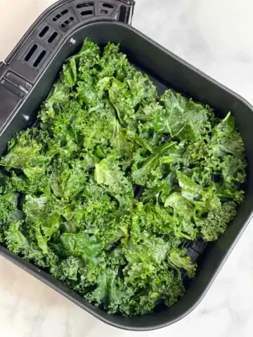 seasoned kale chips added to air fryer basket