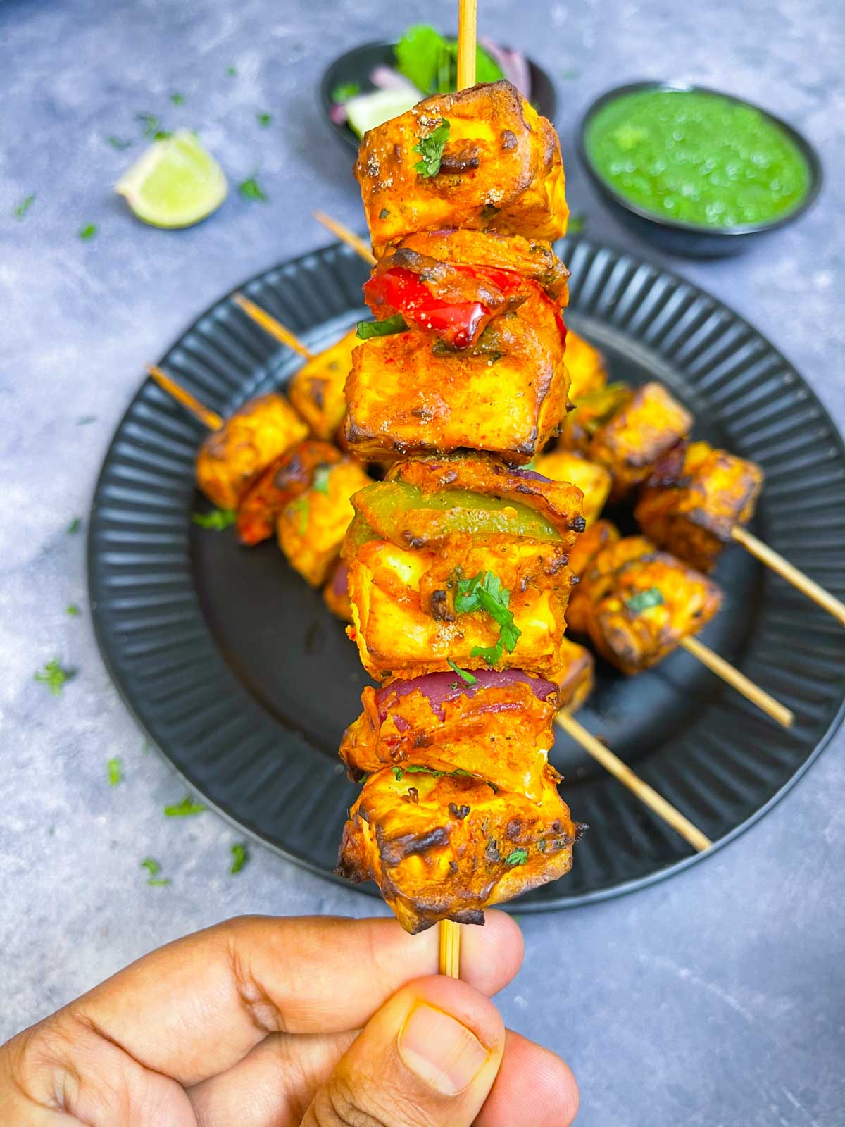 air fryer paneer tikka held in a hand