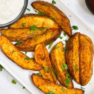 air fried potato wedges served on a plate garnished with cilantro