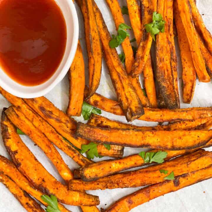 air fryer sweet potato fries served on a plate garnished with cilantro with ketchup on the side