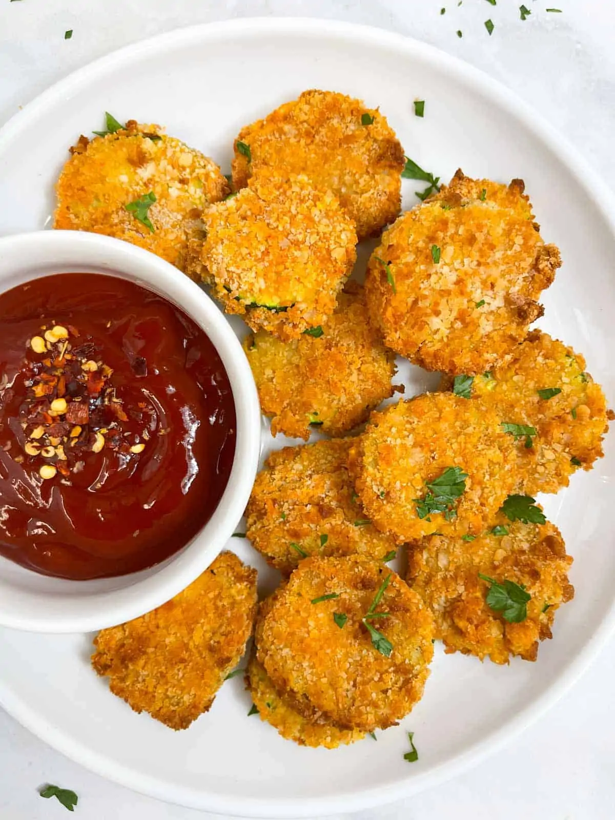 zucchini chips served on a plate with tomato ketchup