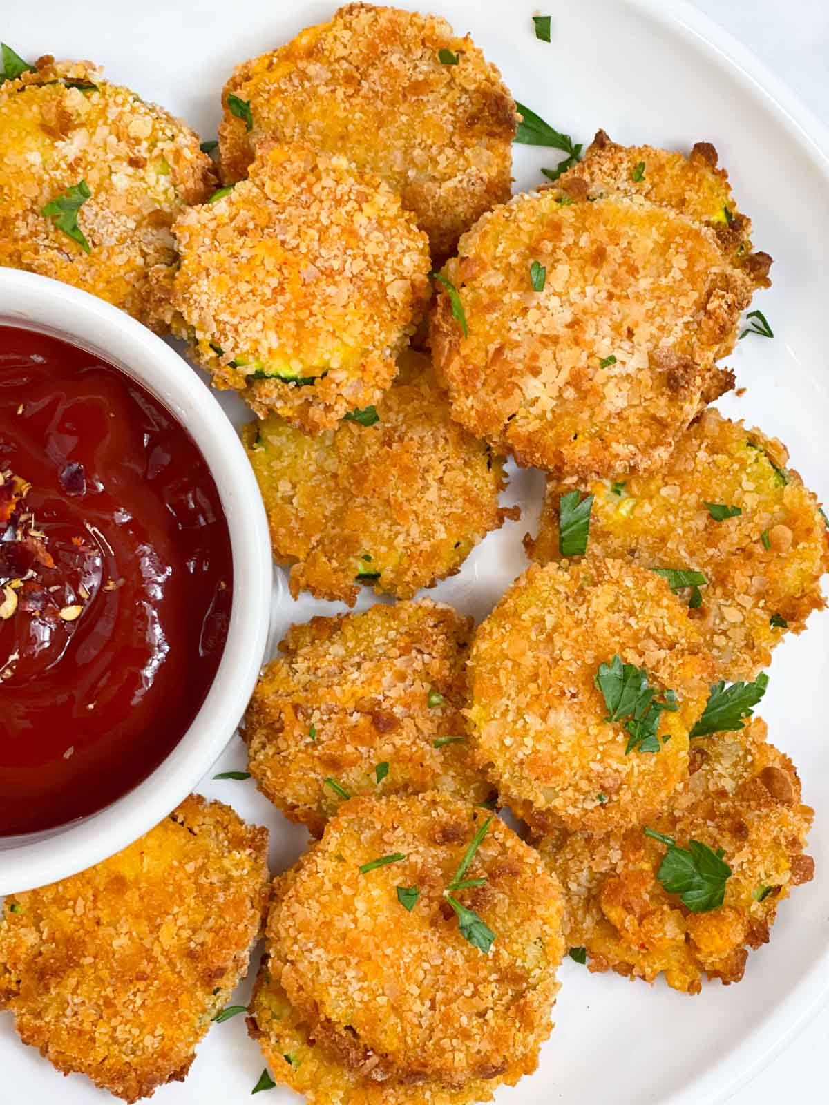 zucchini chips served on a plate with tomato ketchup