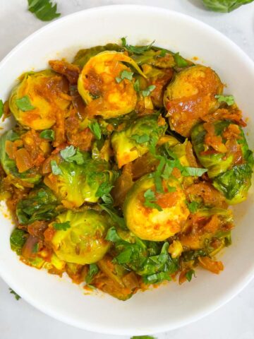 indian brussel sprouts curry served in a bowl garnished with coriander leaves