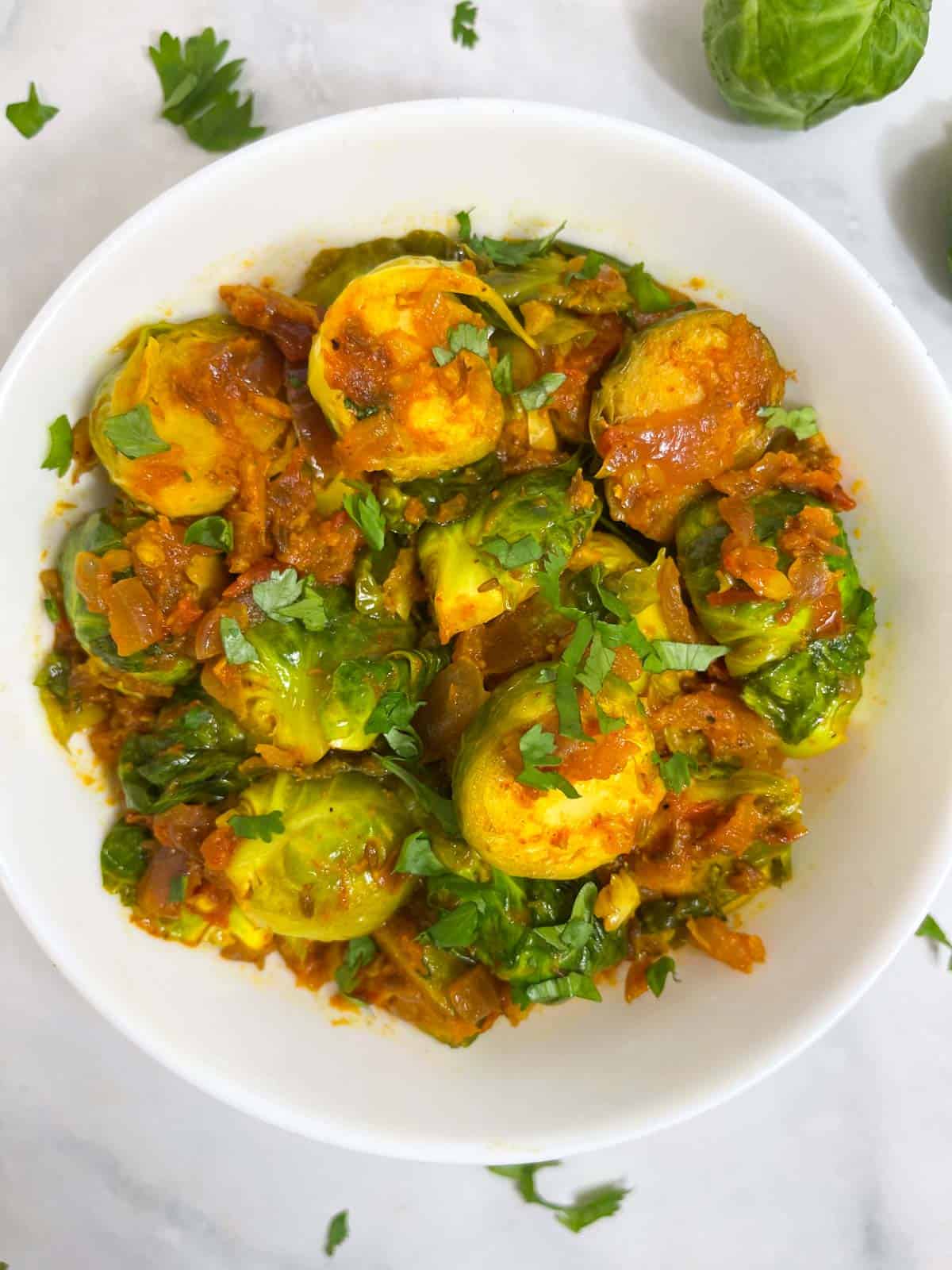 indian brussel sprouts curry served in a bowl garnished with coriander leaves