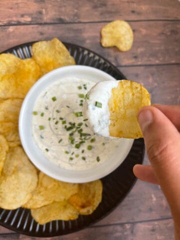 dipping a potato chip into sour cream dip