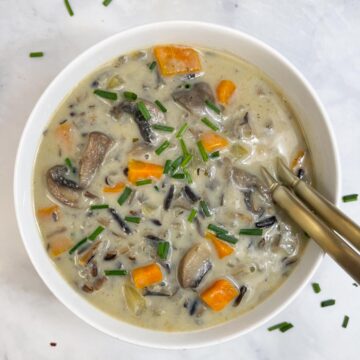 wild rice soup in a bowl with two spoons.