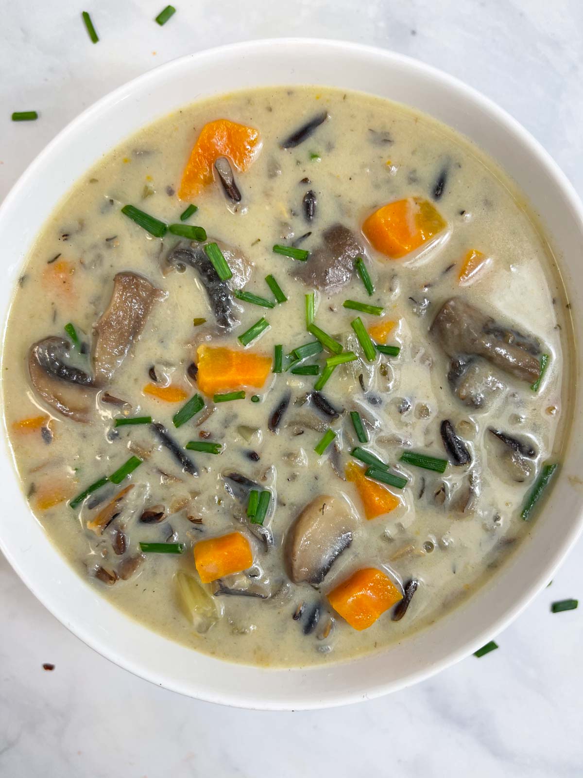 wild rice soup served in a bowl garnished with chives