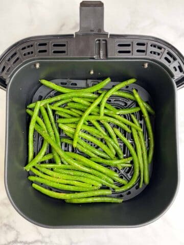 seasoned green beans in the air fryer basket
