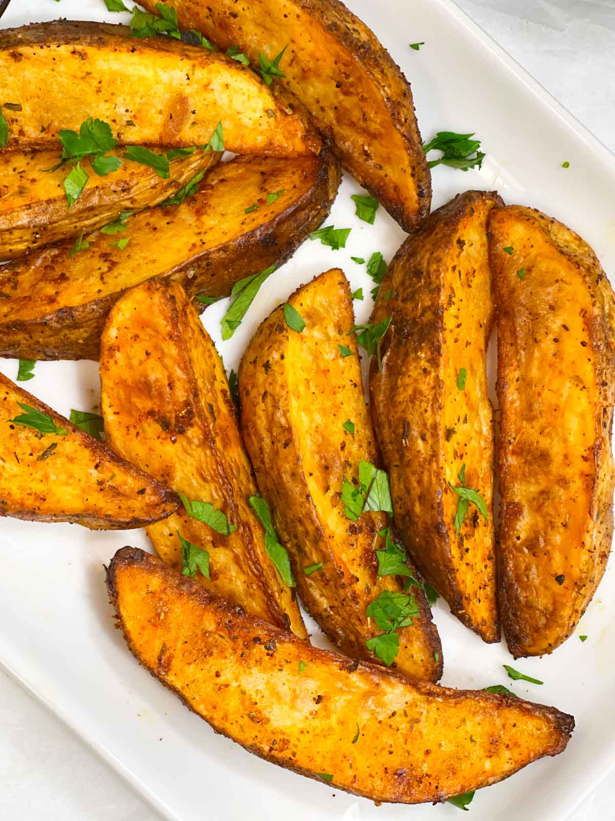 air fried potato wedges served on a plate garnished with cilantro