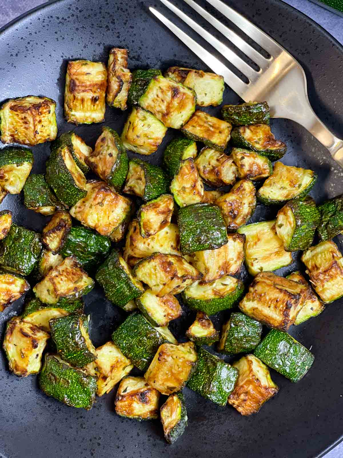 air fryer zucchini on a plate with a fork